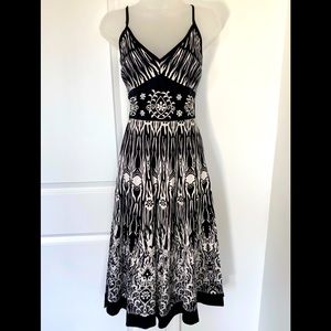 Black and white summer dress with straps and embroidered patterns on the top